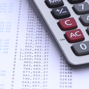 Calculator on financial statement with dollar figures, representing PAYG tax calculations for businesses and employees in Australia.
